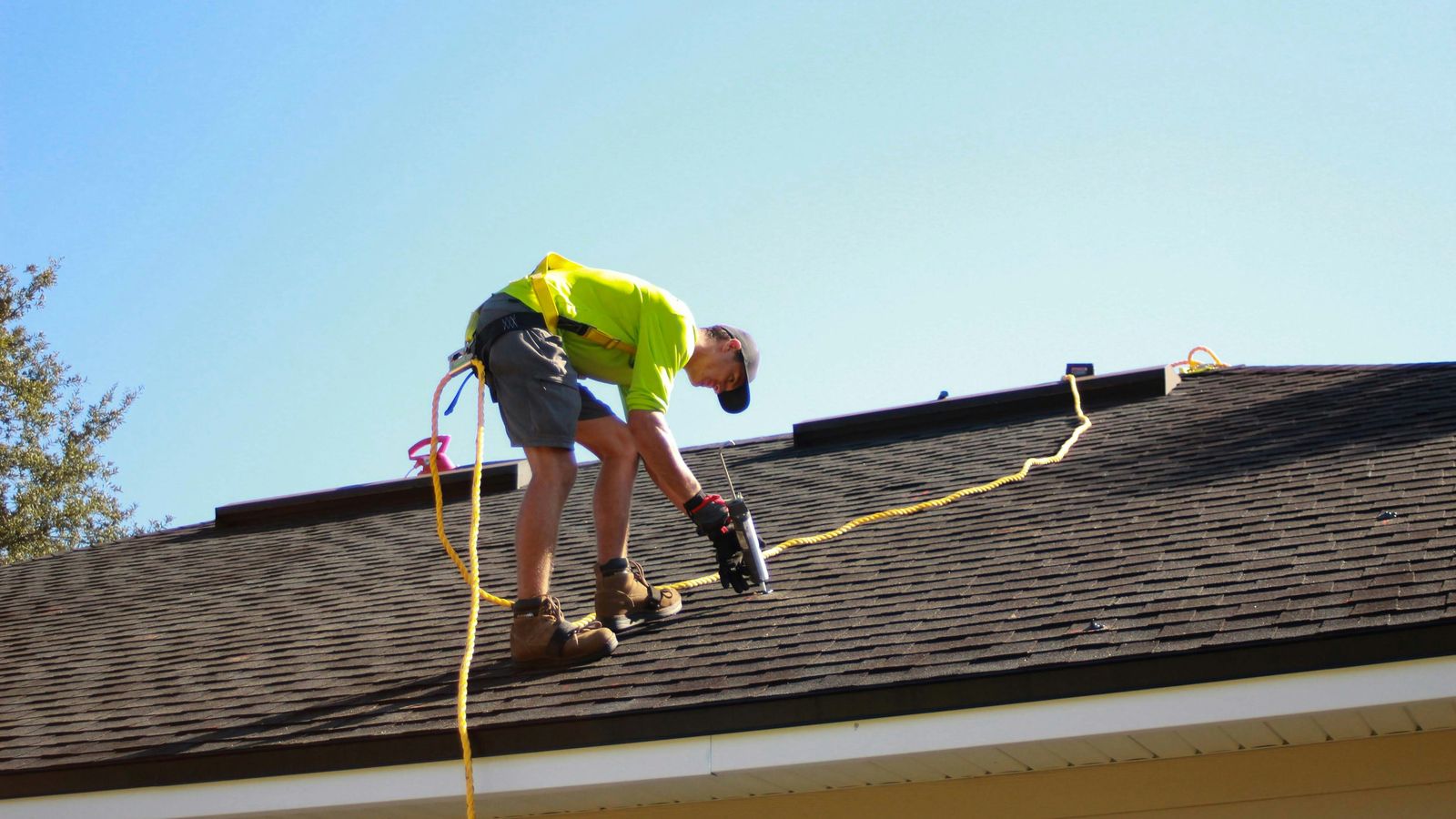 Roofer securing tiles on a pitched roof